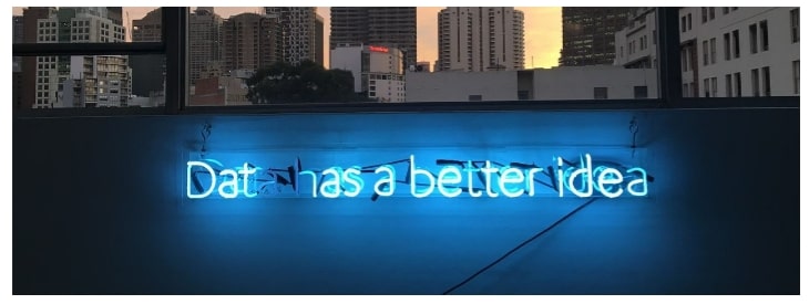 Neon sign with a backdrop of buildings