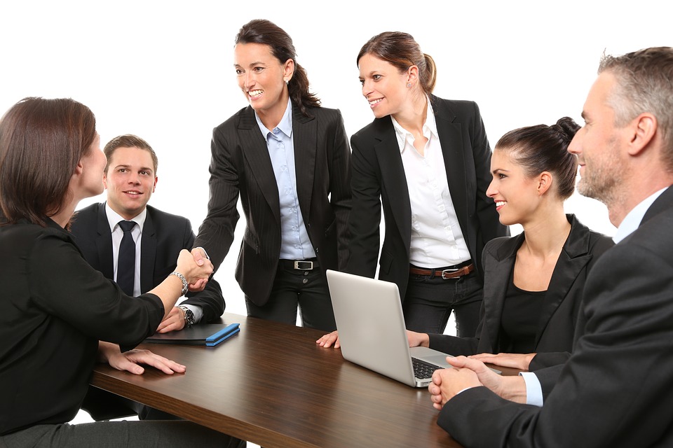 people in suits having a meeting and two people shaking hands