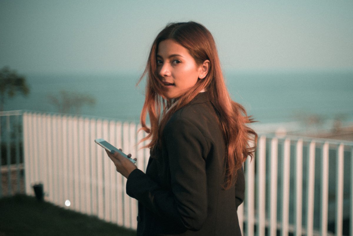 Person turning around to look at a camera while on their phone.