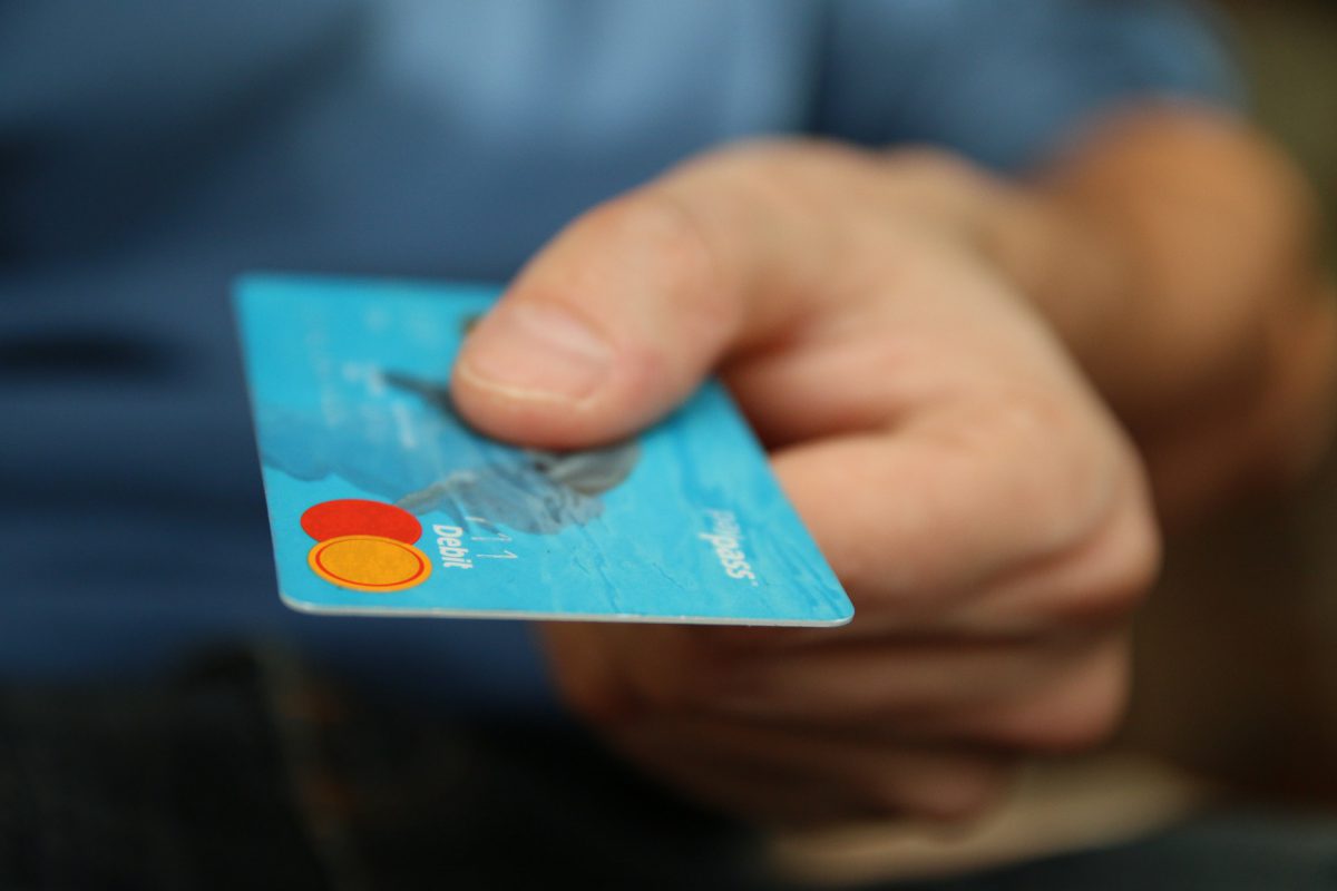 Person handing across a debit card.