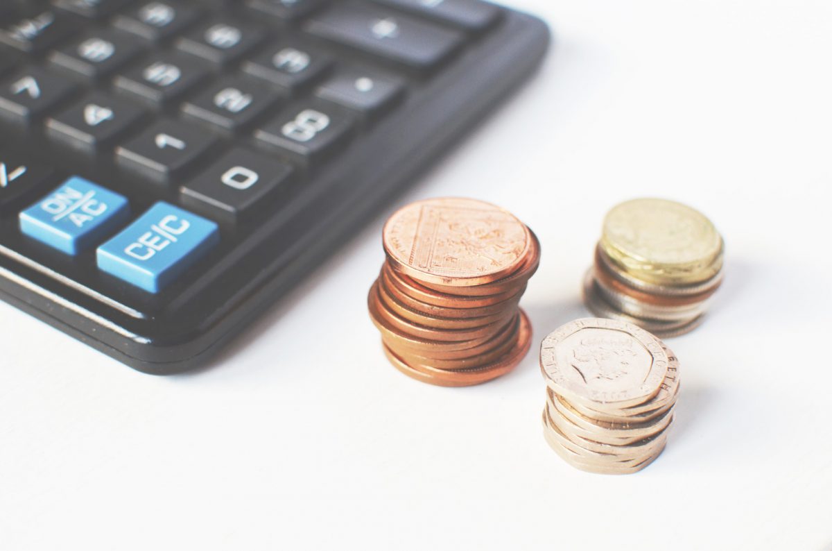 A calculator and stacks of coins on a table