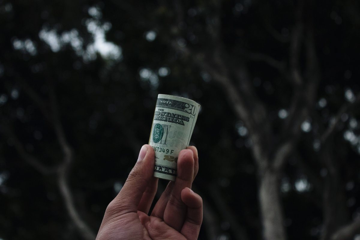 A hand holding a roll of money