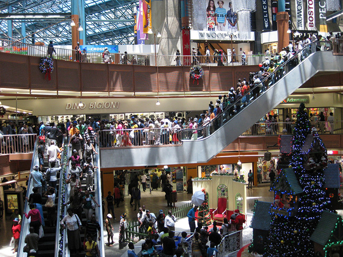 Shopping mall with crowds of people walking up escalators