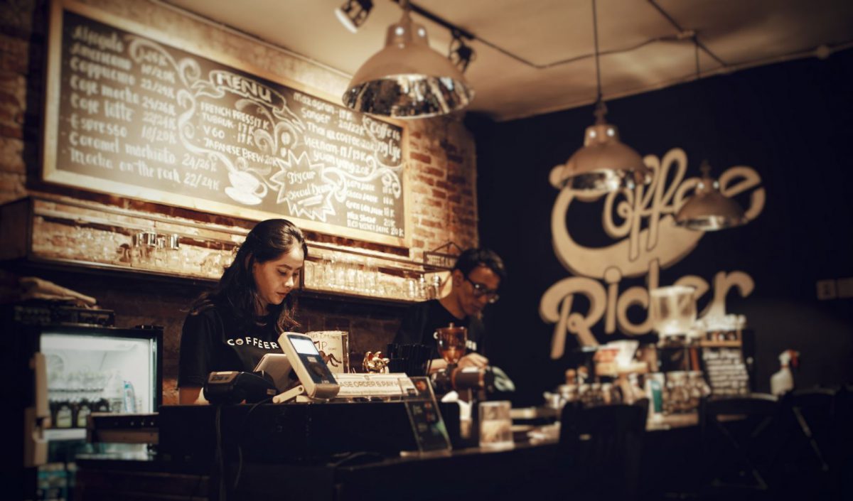 Two people behind a coffee shop counter