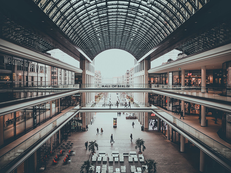 A shopping mall photo, showing stores on both sides.