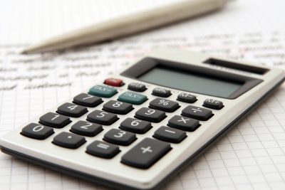 A simple calculator next to a pencil on paperwork