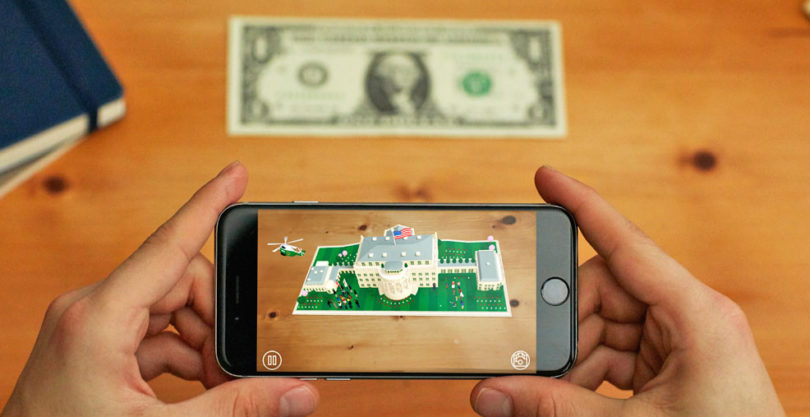 An image showing a mobile phone with an augmented reality image of the white house on it.