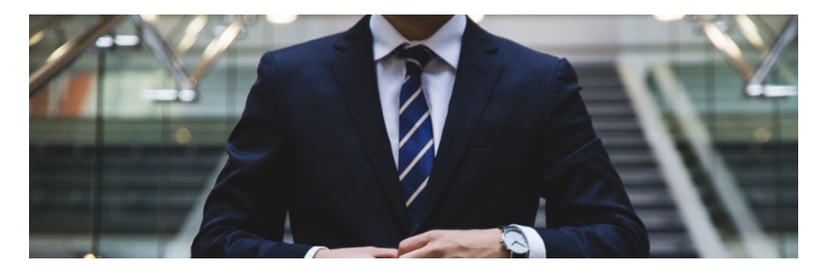 A cropped image showing the torso of a man in a suit