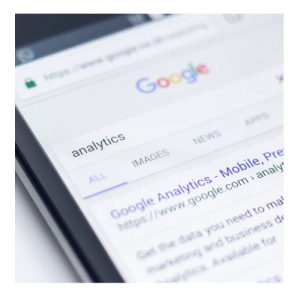 A close up picture of a mobile device with a Google search for analytics displayed