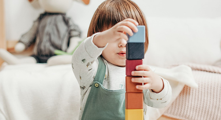 A child stacking colour blocks