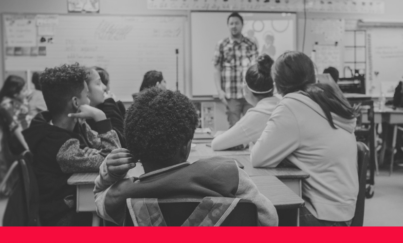 A teacher speaking to a group of children in a classroom