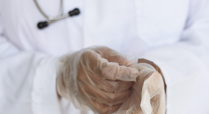 Doctor putting on protective gloves.