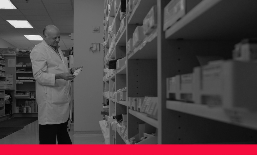 Pharmacist examining a prescription, zoomed in with a red line along the bottom.