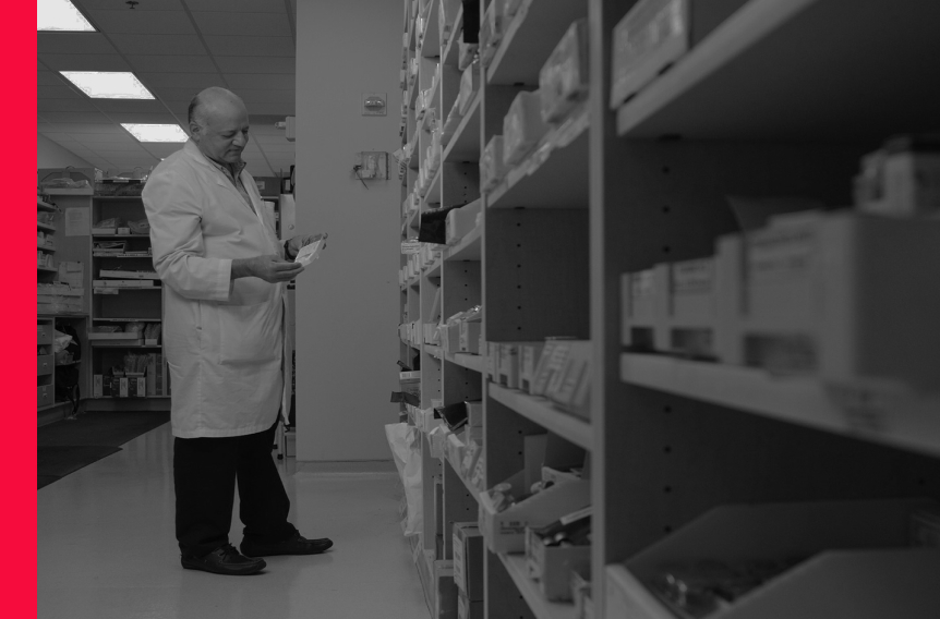 Pharmacist examining a prescription, zoomed in with a red line along the left side.