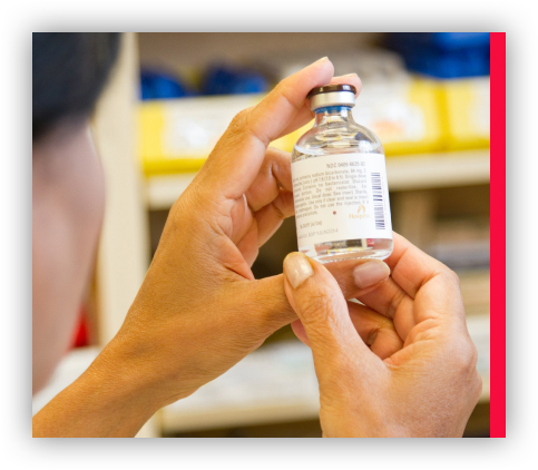 Person examining the text on a bottle of medicine.