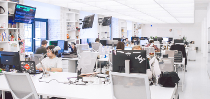 White office with workers sitting at computers