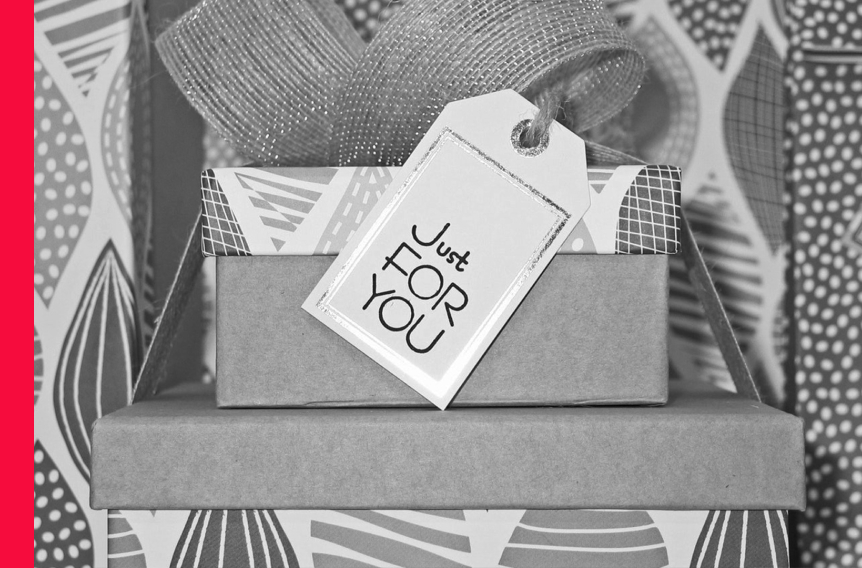 A stack of boxes with a bow and a tag that says just for you