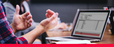 A person sitting in front of a laptop gesturing with their hands during a meeting