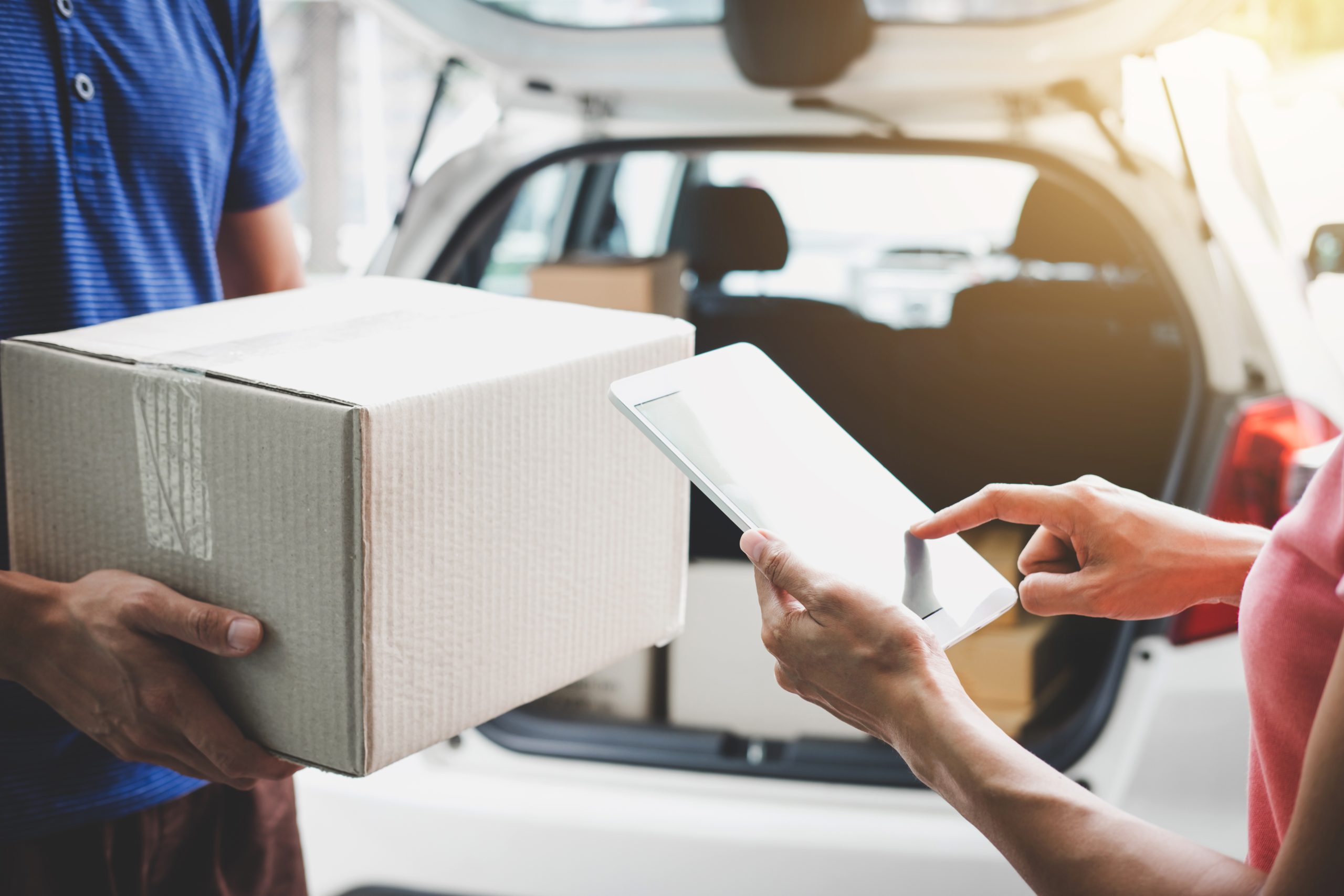 Woman customer appending signature in digital tablet and receiving a cardboard boxes parcel from delivery service courier, Home delivery service and working with service mind.