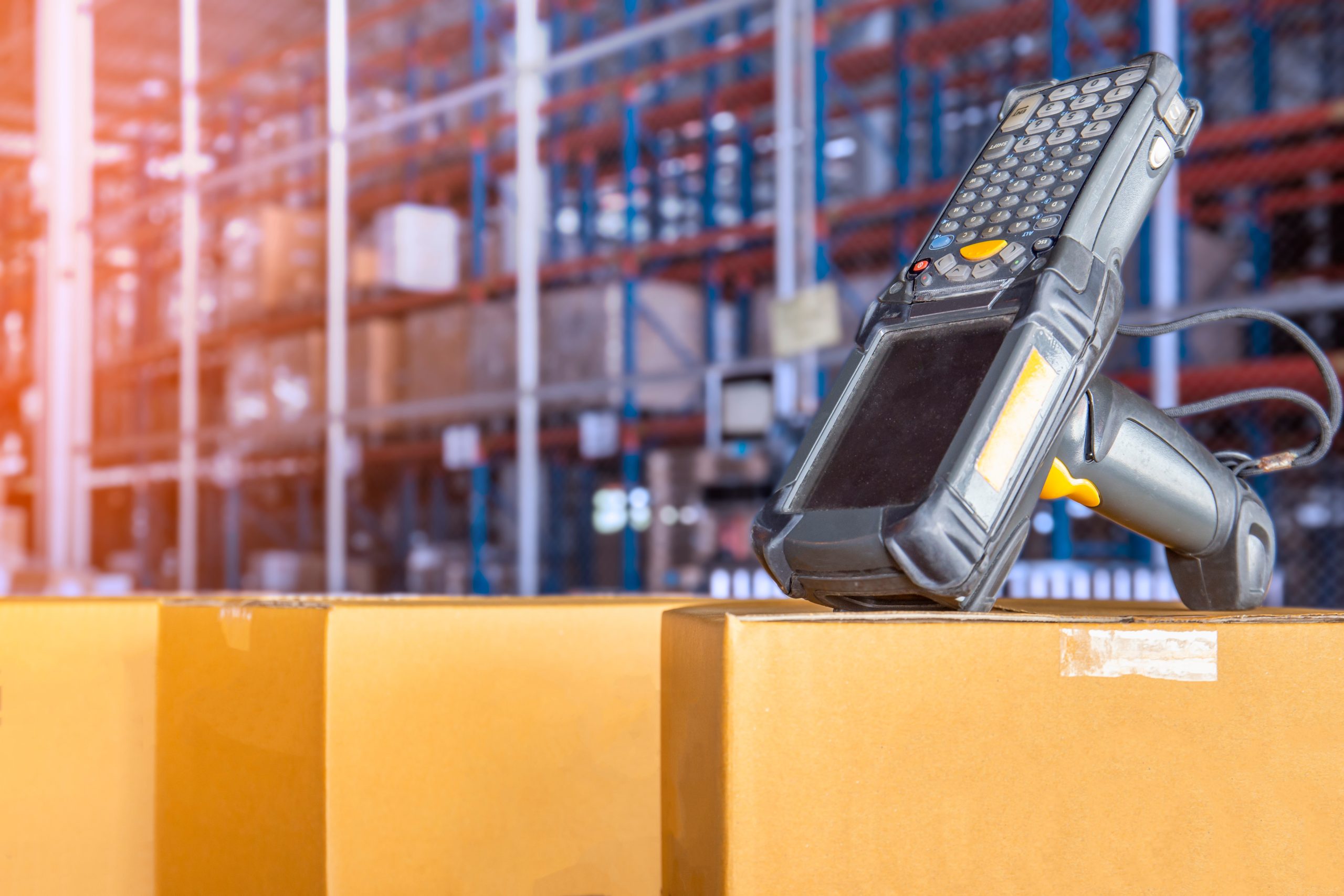 Warehouse scanner sat on a box in a warehouse.