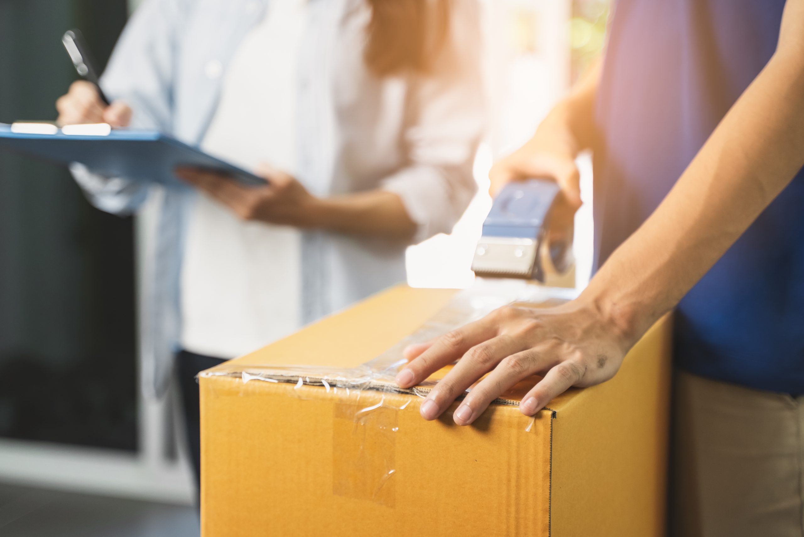 Close up person sealing tape on parcel box prepare for delivery service to pick up.