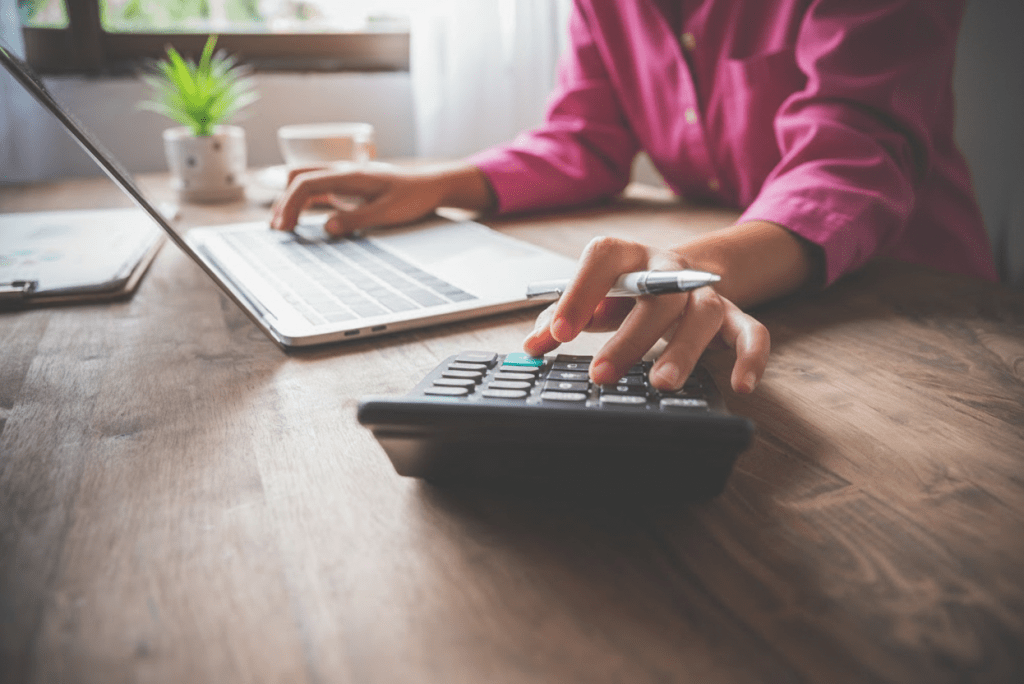 Person sitting at a desk with their laptop and a calculator.