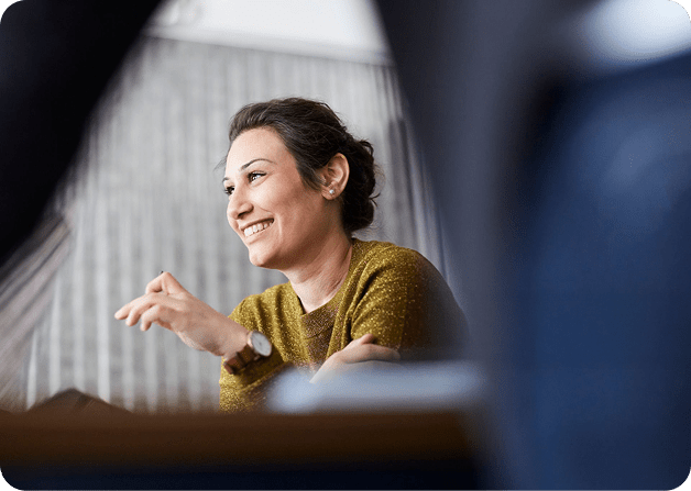 A woman smiling, in a meeting room
