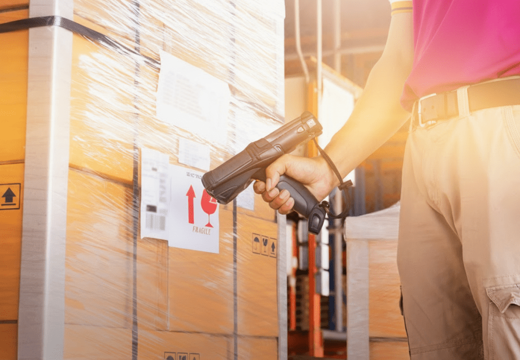 Man holding a hand hold scanner, scanning a barcode on a box.
