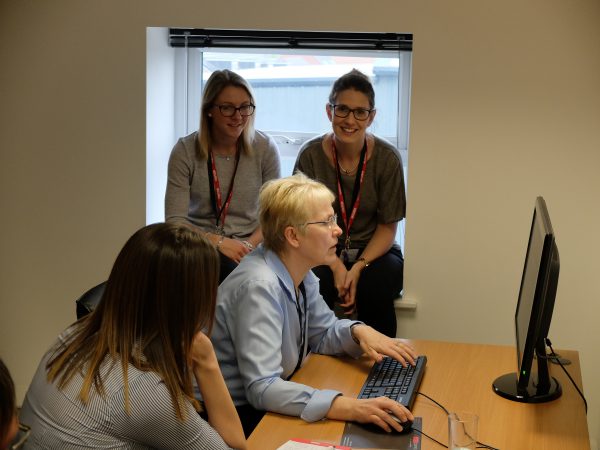 Lindy demonstrating something on a computer to a number of women