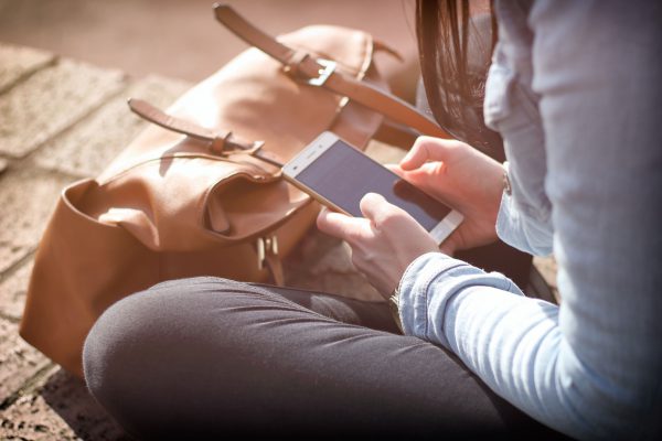 Someone sat down outside using their mobile device.