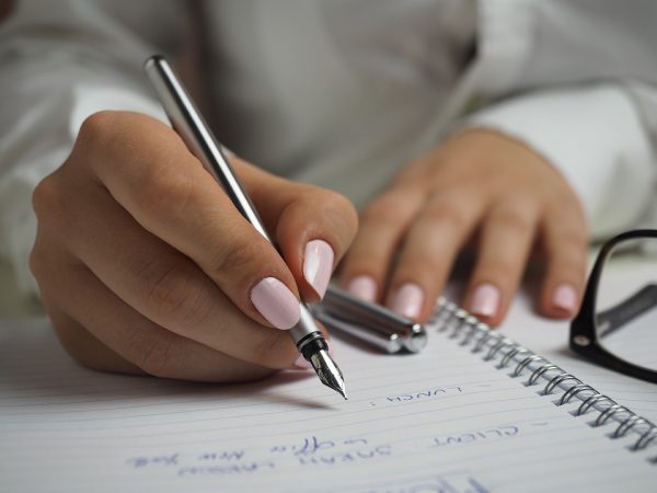 Person writing with a fountain pen.